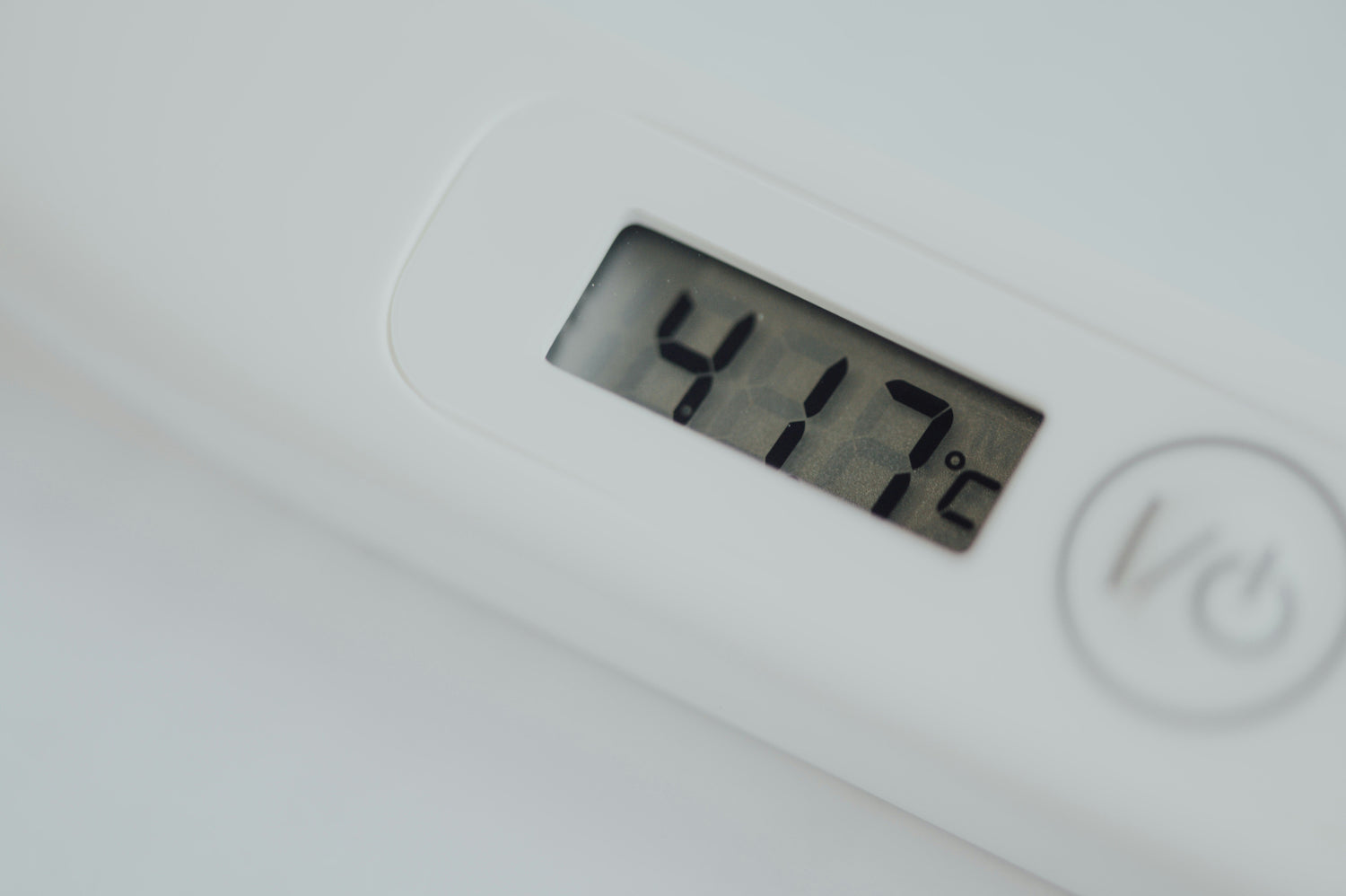 Digital baby thermometer displaying a temperature reading, close-up view on a clean white background